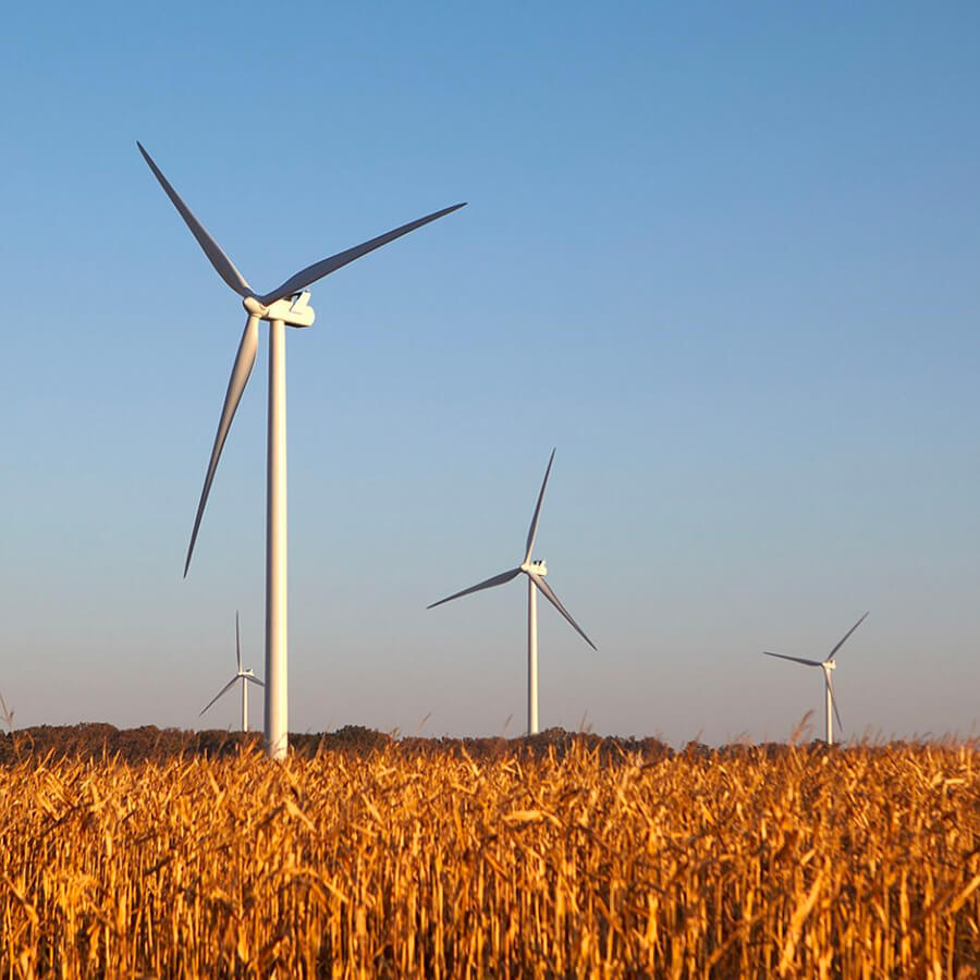 field with blue sky and wind power